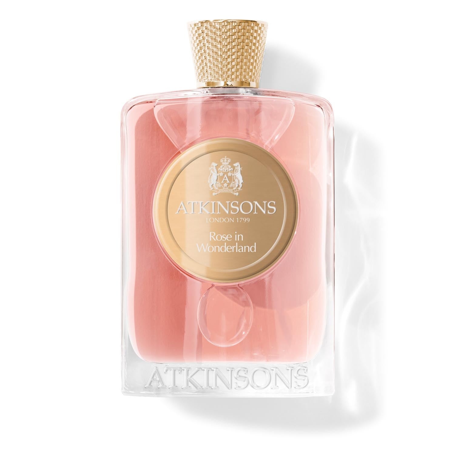 Atkinsons Rose in Wonderland Eau de Parfum 100 ml, skaidrus buteliukas su rausvu skysčiu ir auksiniu medalionu